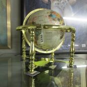 A medium gem set table globe on brass base.