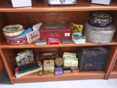 2 shelves of vintage tins