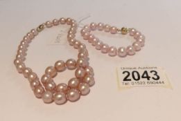 A pink pearl necklace and bracelet.