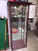 A tall display cabinet with mirror back and 4 glass shleves