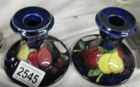 A pair of Moorcroft wisteria candlesticks, approx. 3.35" / 8.25 cm tall.