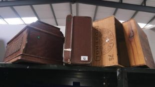 A vintage suitcase, crate, wooden sewing machine lid and wooden box.