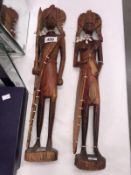 A pair of tribal figures decorated with beads.