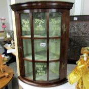 A glazed corner cabinet with stencilled Fry's Chocolate advert.