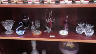 A shelf of glassware including paperweights, vases etc.