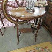 An Edwardian oval mahogany table with string inlay.