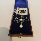 A necklace set with diamonds, seed pearls and pearls in a brown box.