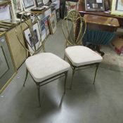A pair of brass shield back ball room chairs.