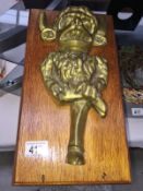 A large brass Lincoln Imp key holder on wood