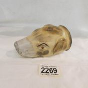 A stirrup cup in the form of a fox hound head.