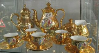 A gilded coffee set decorated with classical scenes.