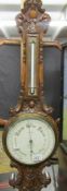 A carved oak barometer/thermometer marked Rae Bros., 77, Renfield St., Glasgow.