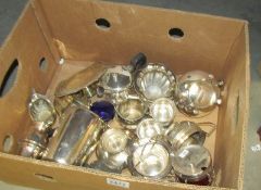 A box of assorted silver plate including sugar bowls, milk jugs etc.