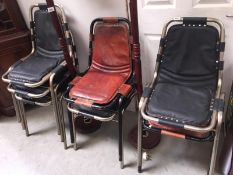 7 metal chairs with leather seats and backs.
