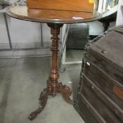 A walnut veneer tripod table (some veneer lifting).
