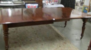A Victorian mahogany wind out extending dining table with 2 extra leaves.