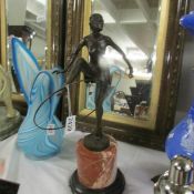 A bronze art deco style figure with hoop on marble plinth.