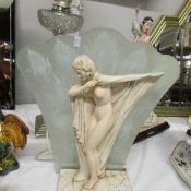 A nude figure table lamp with fan shaped glass shade.