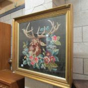 A framed and glazed tapestry depicting a stag.