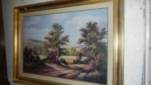 A large gilt framed and glazed woodland scene.