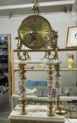 A porcelain and brass 4 pillar mantel clock with pendulum.