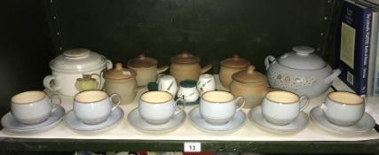 A shelf of Denby stoneware tea and dinner ware