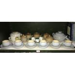 A shelf of Denby stoneware tea and dinner ware