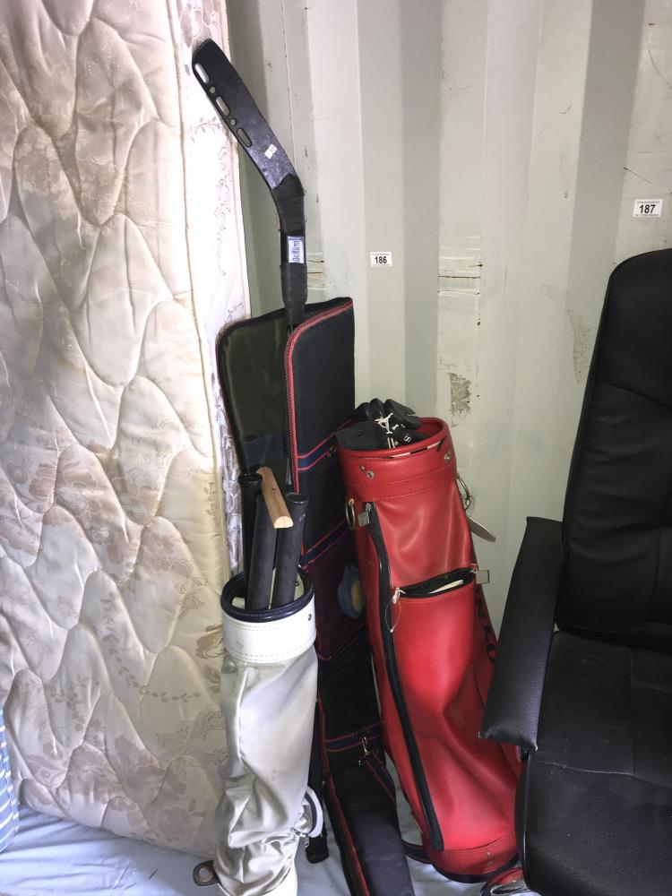 2 golf bags and an ice hockey stick