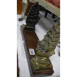 A pair of brass ship book ends mounted on a wooden base.