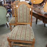A pair of oak chairs with upholstered seats and backs.