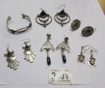 5 pairs of silver earrings and a silver bangle.