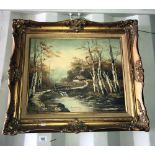 A decorative gilt framed oil on canvas of a woodland stream and cottage