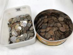 A tin of British coins and a tub of foreign coins