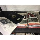 A folder containing an assortment of Manchester United football programmes from 1950's to 1980's