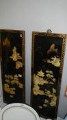 A pair of Japanese lacquered panels with mother of pearl figures.