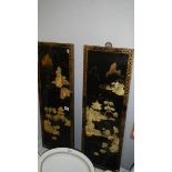 A pair of Japanese lacquered panels with mother of pearl figures.