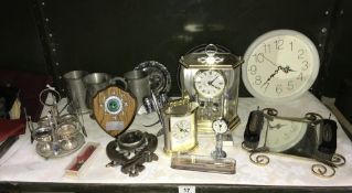 A shelf of clocks, pewter tankards, aeroplane cruet etc.