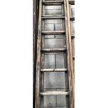 A set of wooden double extending ladders