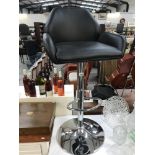 An adjustable black leather and chrome bar/counter chair