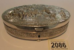An oval embossed metal box marked Zilfla90