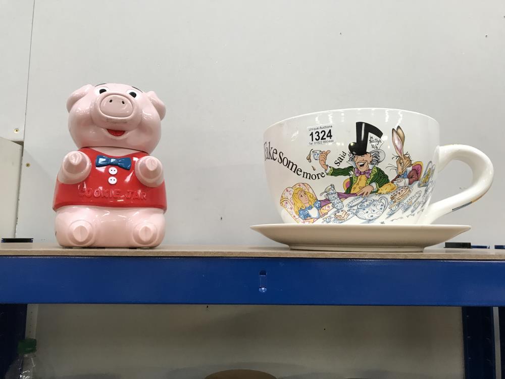 A large Alice in Wonderland cup and saucer and a novelty pig cookie jar