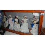 5 dolls in servant's costumes in a glass display case.