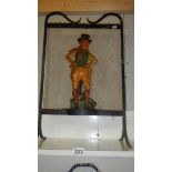 A wrought iron and mesh fire screen with cast iron figure to front.