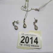 A silver pendant with matching earrings.