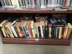 A shelf of paperbac books including Sci-Fi