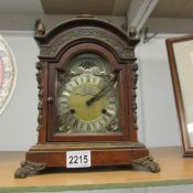 An ornate bracket clock with fretwork panels and moon phase dial marked W C Pales, London.