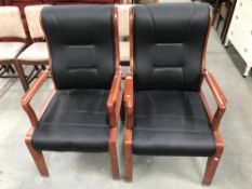 A pair of wood framed faux leather chairs