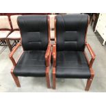 A pair of wood framed faux leather chairs