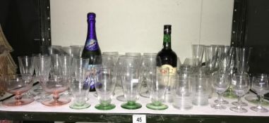 A quantity of drinking glasses and a bottle of Q.C.