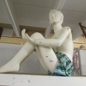 A seated boy mannequin.